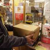 Customers weigh packages at the post office.