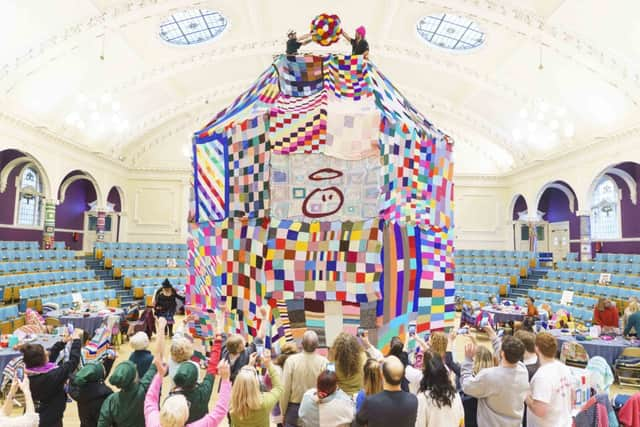 People watch as workers place a giant bobble on top of a 23 foot high bobble hat in celebration of the 20th anniversary of the innocent Big Knit in partnership with Age UK (photo: Dominic Lipinski/PA Wire)