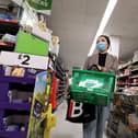 A shopper wears a protective mask as she walks down an aisle in a supermarket (Getty Images)