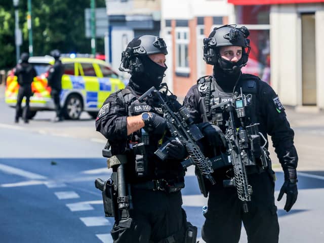 Armed police on Ilkeston Road, Nottingham, which is cordoned off after two people were found dead in the street.