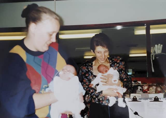 Bronwyn is held by mum Debbie as a baby, and Jack is held by mum Sharon.