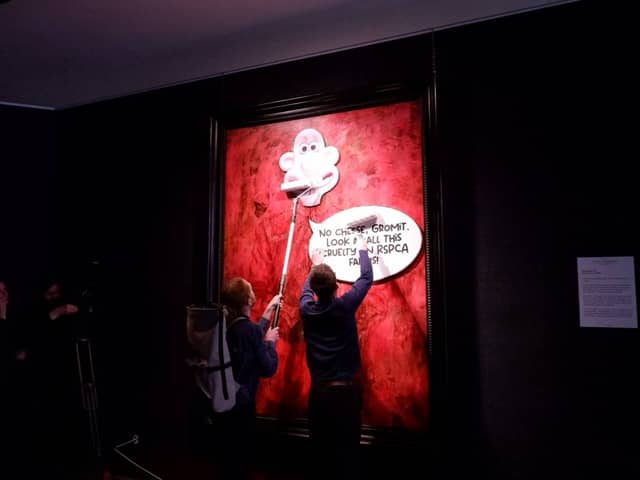 Protesters pasting over the royal portrait (Photo: Animal Rising/Supplied)
