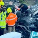 Footage of the aftermath of a car crash that left two pedestrians hospitalised shows a man being pulled from the wreckage.  