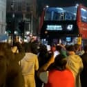 Excited England fans dance around “Bellingham” bus.