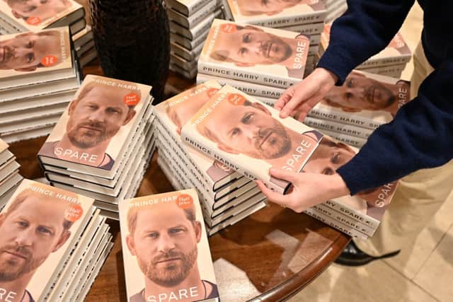 Prince Harry Spare: When does it come out in paperback and are there any new additions? A bookseller holds a copy of "Spare" by Britain's Prince Harry, Duke of Sussex, at Waterstones' flagship Piccadilly bookshop on the day of its release in London, on January 10, 2023 (Photo by AFP via Getty Images)