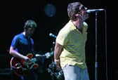 Liam (R) and Noel Gallagher perform on stage. Photo: JOSE JORDAN/AFP via Getty Images