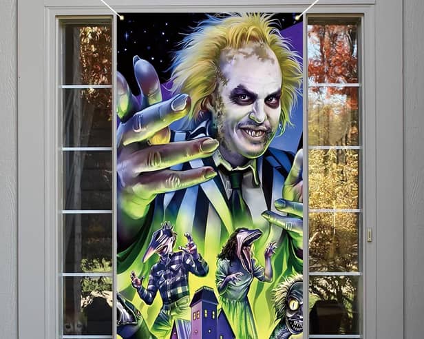Beetlejuice themed Halloween decorations like this door cover are all the rage this year