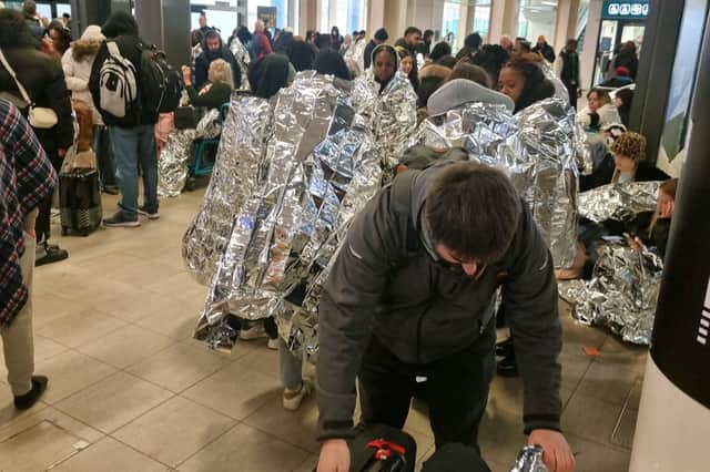 Evacuated Gatwick Airport passengers wrap themselves in foil blankets.
