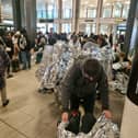 Evacuated Gatwick Airport passengers wrap themselves in foil blankets.
