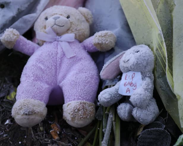 Flowers and stuffed toys are left as tributes to 'Baby A'.