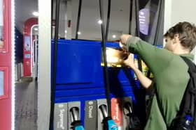 Dr Patrick Hart cracks the display panels of petrol pumps at Esso Thurrock Services on the M25 on August 24 2022. 