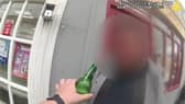 Man tries to take swig of his lager while being arrested for drink driving.