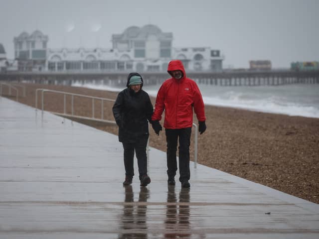 A couple walk in heavy rain on the South Parade Pier, in Portsmouth.