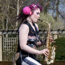 Rachel Ward unicycling while playing the saxophone