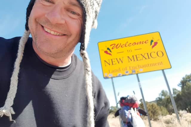 Tom, sporting a beanie, walks into New Mexico