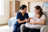 Midwife helping a mother (stock image)