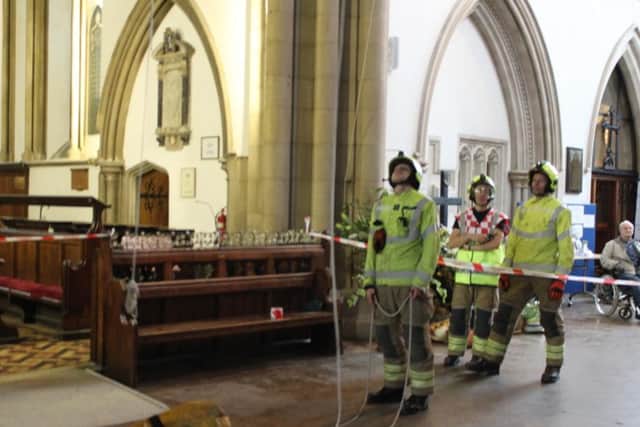 Firefighters waiting for the casualty dummy to be lowered to the ground floor of the church