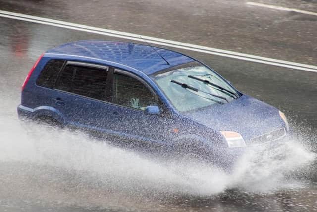 File photo: Car drives through a puddle