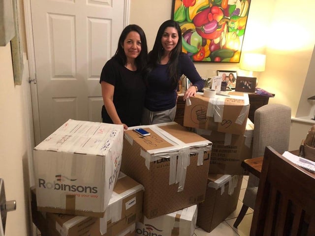 Iliana and Deyali prepare the boxes of clothes, toys and chocolate to send to children in Venezuela