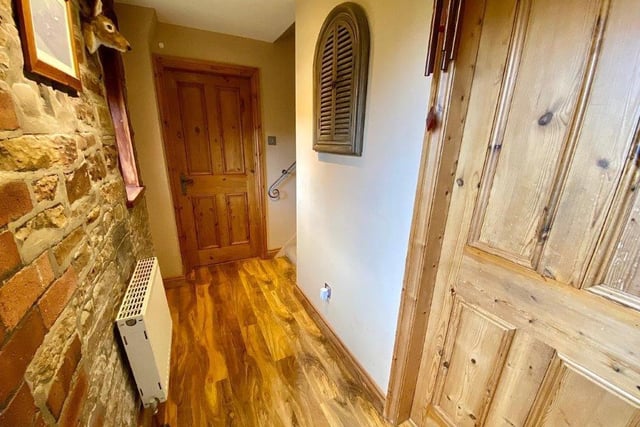 The hallway with exposed brick wall has oak doors through to the various rooms.