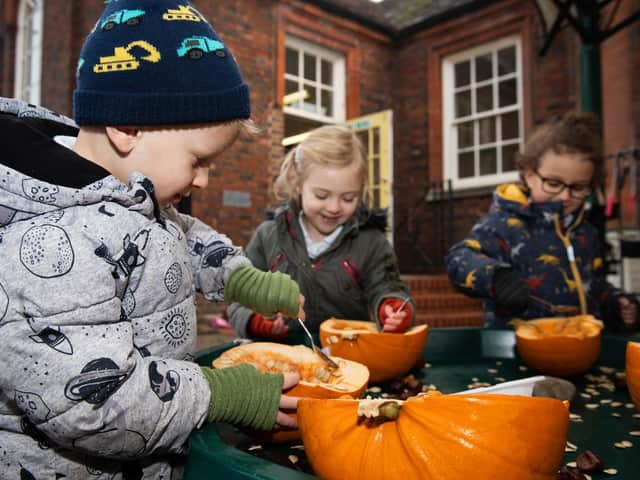 Youngsters carving pumpkins wearing the new handwarmers
