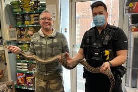 Special delivery: PC James Holmes hands over the snake at Wrigglies, Leighton Buzzard
