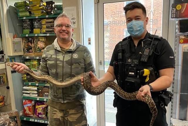 Special delivery: PC James Holmes hands over the snake at Wrigglies, Leighton Buzzard
