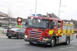 Firefighters used cutting equipment to free a man trapped in a car which overturned and ended up in a ditch