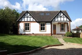 A gravelled driveway leads up to the house