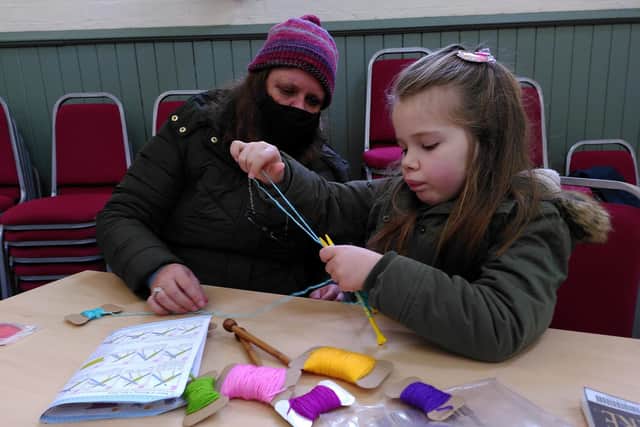 Six-year-old Lily being taught to knit at the St Laurence Repair Cafe
