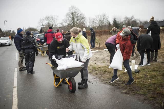 Residents fill bags with sand to protect their homes as Storm Malik hits Scotland.