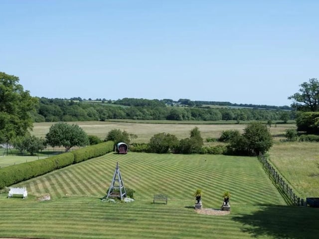 The house is surrounded by grounds and parkland