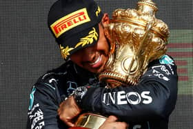 VICTORY: Lewis Hamilton embraces the British Grand Prix trophy after winning at Silverstone on Sunday (Photo Daimler AG)