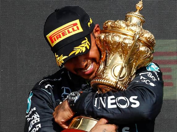 VICTORY: Lewis Hamilton embraces the British Grand Prix trophy after winning at Silverstone on Sunday (Photo Daimler AG)