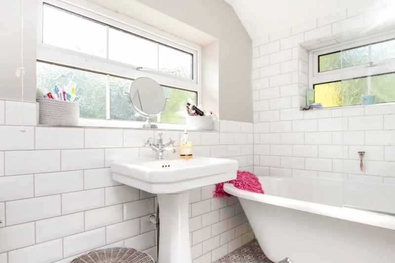 The bathroom features a rolltop bath