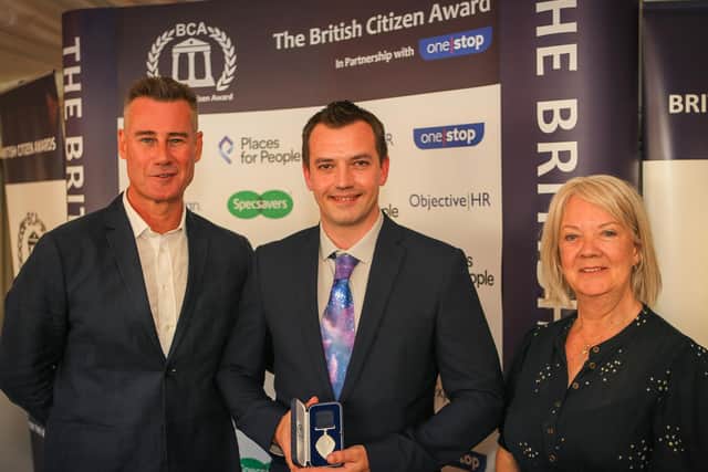 Ross receiving his medal from television presenter Tim Vincent (left) and Dame Mary Perkins of Specsavers
