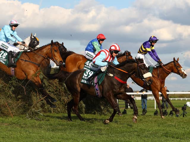 Corach Rambler (far side) jumps one of Aintree's famous fences, The Chair, on his way to victory in last year's Grand National.
