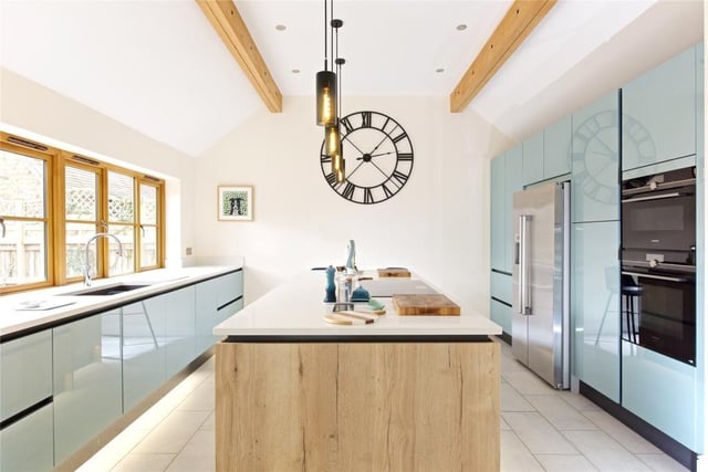 The central island in the kitchen has a breakfast bar and induction hob with a downdraft extractor