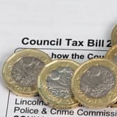 New pound coins on a council tax bill, photo by Shaun Wilkinson