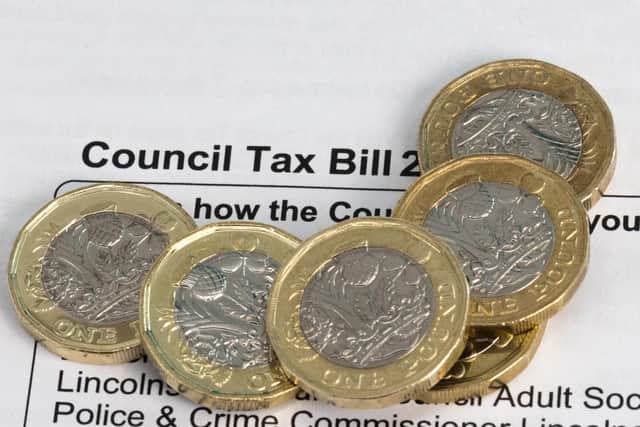 New pound coins on a council tax bill, photo by Shaun Wilkinson