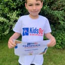 Proud seven-year-old Joshua Cowley with his Certificate of Appreciation from KidsOut