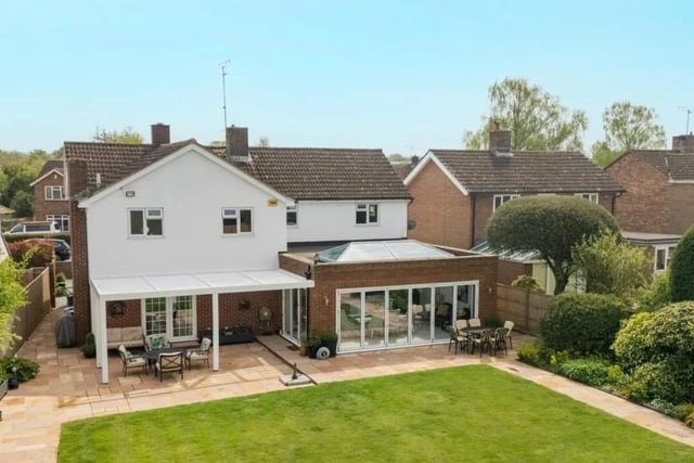 An aerial view of the rear of the property partially encompassing the expansive garden and delightful decking in the home.