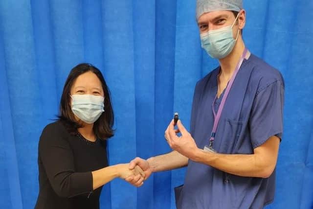 Consultant Surgeons Dr Fiona Tsang-Wright and Nicholas Holford with a bottle containing the lymphatic tracer Magtrace