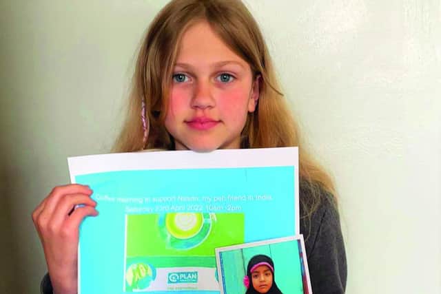 Isla Bentley holding a poster she made for the event and a photo of Nasrin