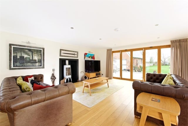 The sitting room which features log burner, bi-fold doors and dual aspect windows
