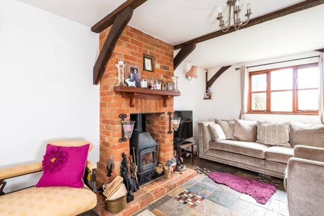 One of three reception rooms in the home, it has a brick feature fireplace housing a log burning stove, and double doors to the conservatory.