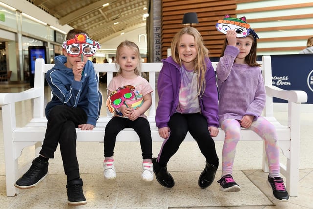 Youngsters show off the puppy masks they made a free craft workshop