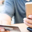 A person looks at their bank card and mobile phone. PIC: Alamy/PA