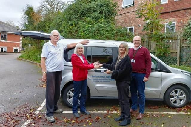 Representatives from The Barbara Bus Fund hand over the keys to the home's activity co-ordinator