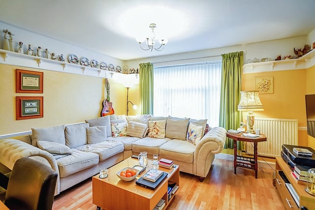 The spacious living area benefits from a large picture window overlooking the garden.